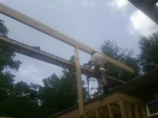 Carpenter setting a ridge beam over a new addition frame — Ice Dam Removal by Roofing Brothers in Huntington Beach