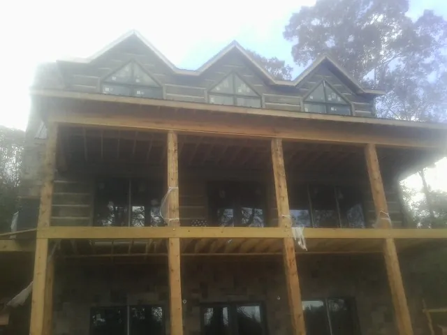 Dormers and porch framing on a large log home under construction — Roof Coating work by our crew in Huntington Beach
